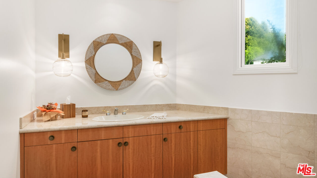 27445 Winding Way Malibu, CA 90265 - Photo 52 of 59 a bathroom with a granite countertop sink a mirror and a window