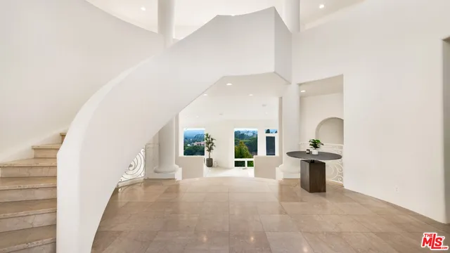 a living room with furniture floor to ceiling window and a flat screen tv