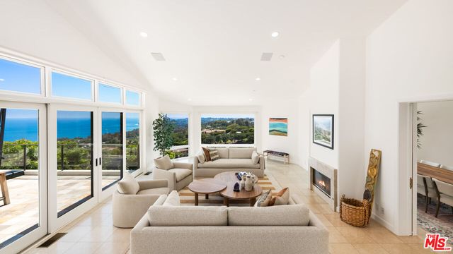 a living room with fireplace furniture and a floor to ceiling window