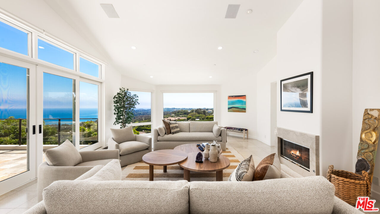 27445 Winding Way Malibu, CA 90265 - Photo 8 of 59 a living room with fireplace furniture and a floor to ceiling window