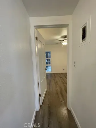 a view of a hallway with wooden floor and closet