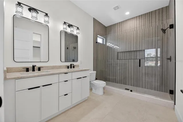 a bathroom with a toilet a sink a mirror a bathtub and shower