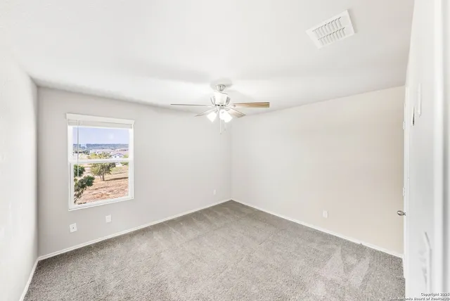 a view of a livingroom with a ceiling fan and window