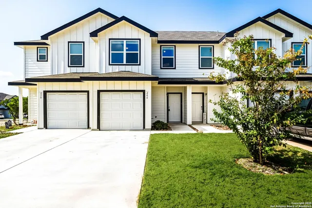 a front view of a house with a yard and garage