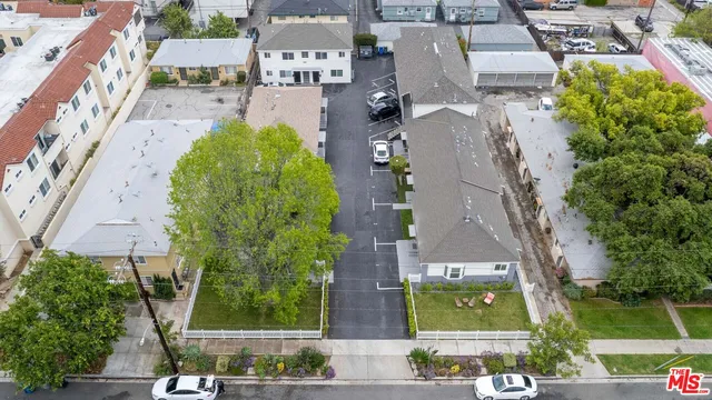 an aerial view of residential houses with outdoor space and street view