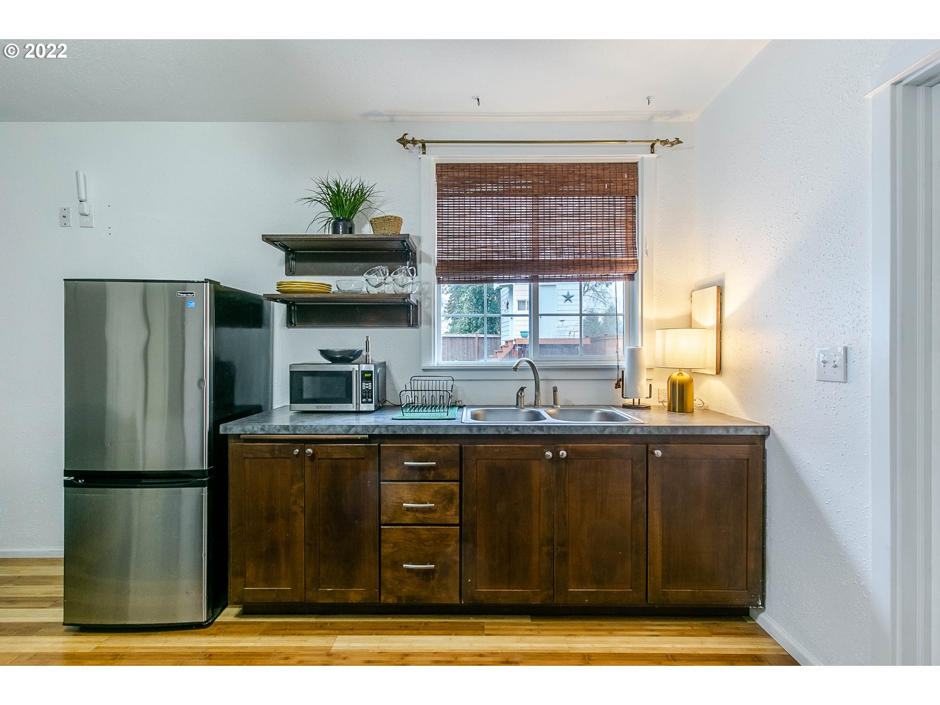 1597 Balboa Street Eugene, OR 97408 - Photo 26 of 27 a kitchen with granite countertop a refrigerator a sink a stove and wooden floors