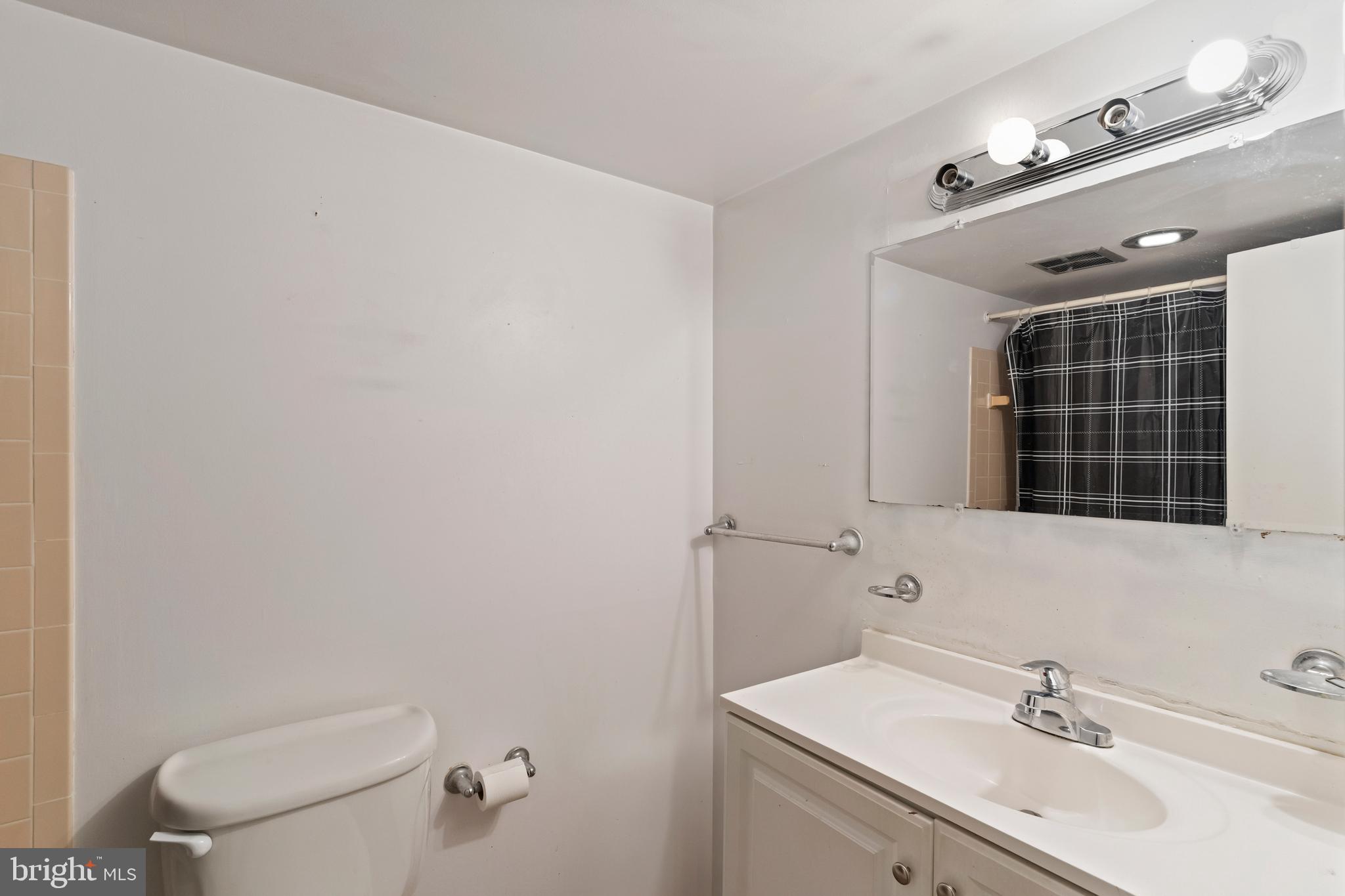 3362 Woodburn Road, Unit 13 Annandale, VA 22003 - Photo 16 of 19 a bathroom with a sink mirror vanity and toilet