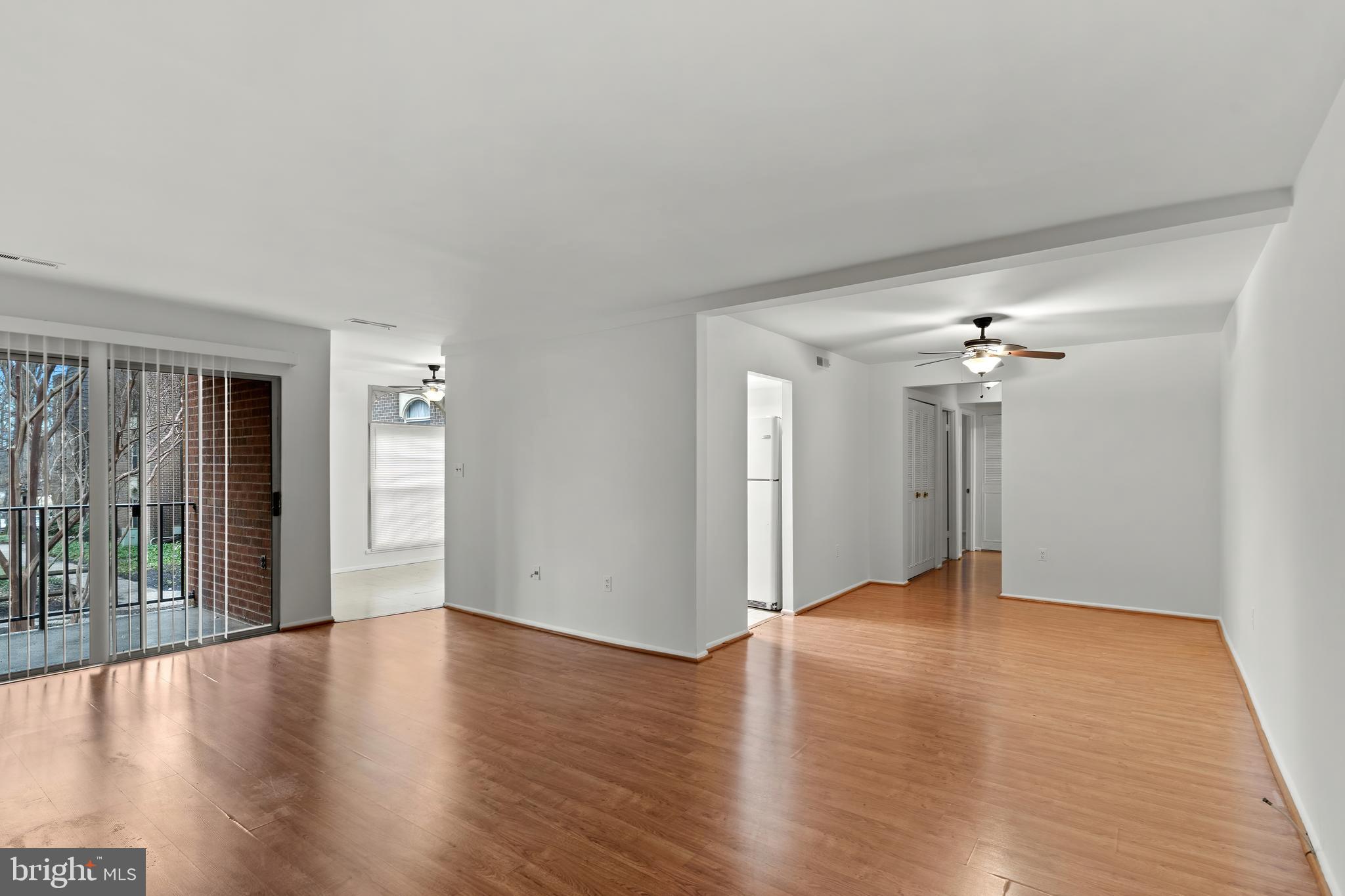 3362 Woodburn Road, Unit 13 Annandale, VA 22003 - Photo 3 of 17 an empty room with wooden floor chandelier fan and windows