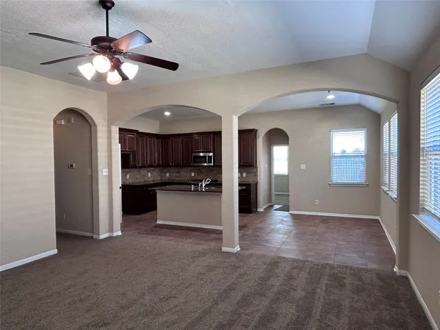 a view of a hallway with kitchen and chandelier