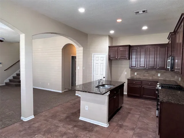 a kitchen with granite countertop a stove and a sink