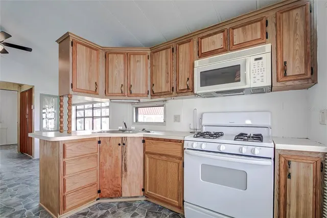 a kitchen with stainless steel appliances granite countertop a stove microwave and cabinets