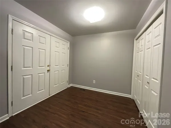 an empty room with wooden floor and closet area