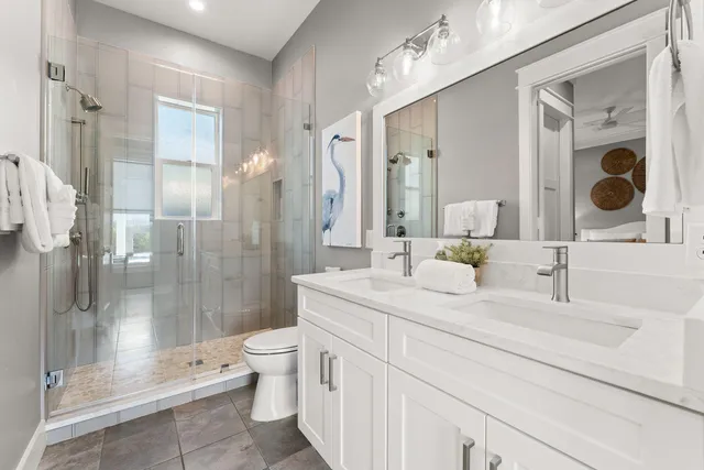 a bathroom with a double vanity sink toilet and shower