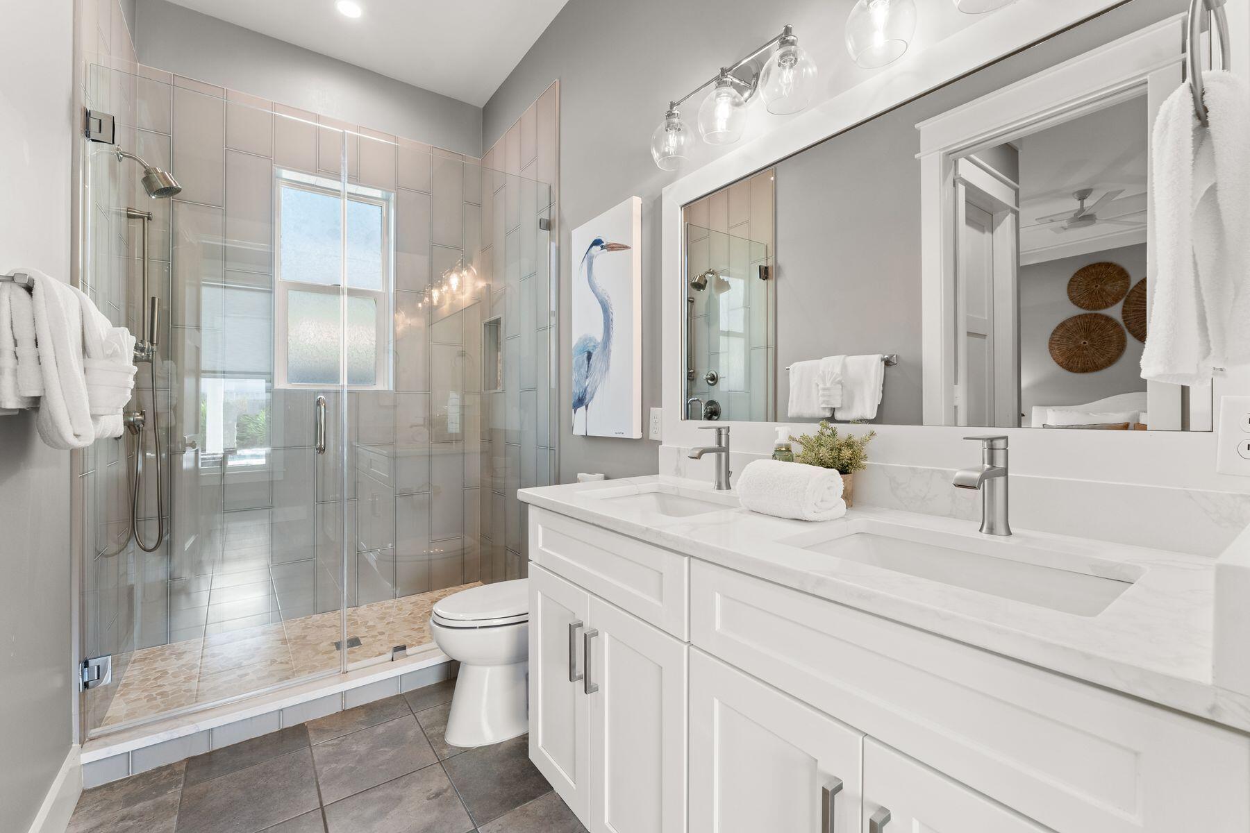 389 Seacrest Drive Seacrest, FL 32461 - Photo 16 of 33 a bathroom with a double vanity sink toilet and shower