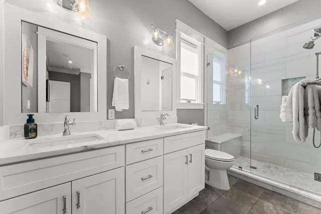 a bathroom with a double vanity sink toilet and shower