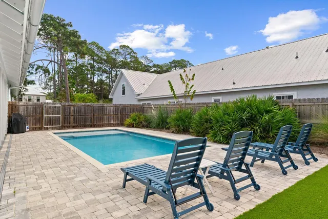 a swimming pool with outdoor seating and yard