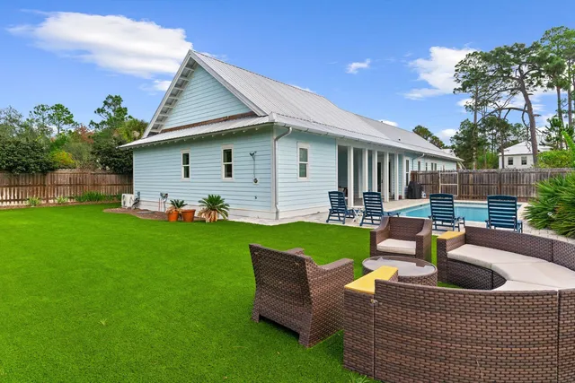 a view of a house with backyard and sitting area