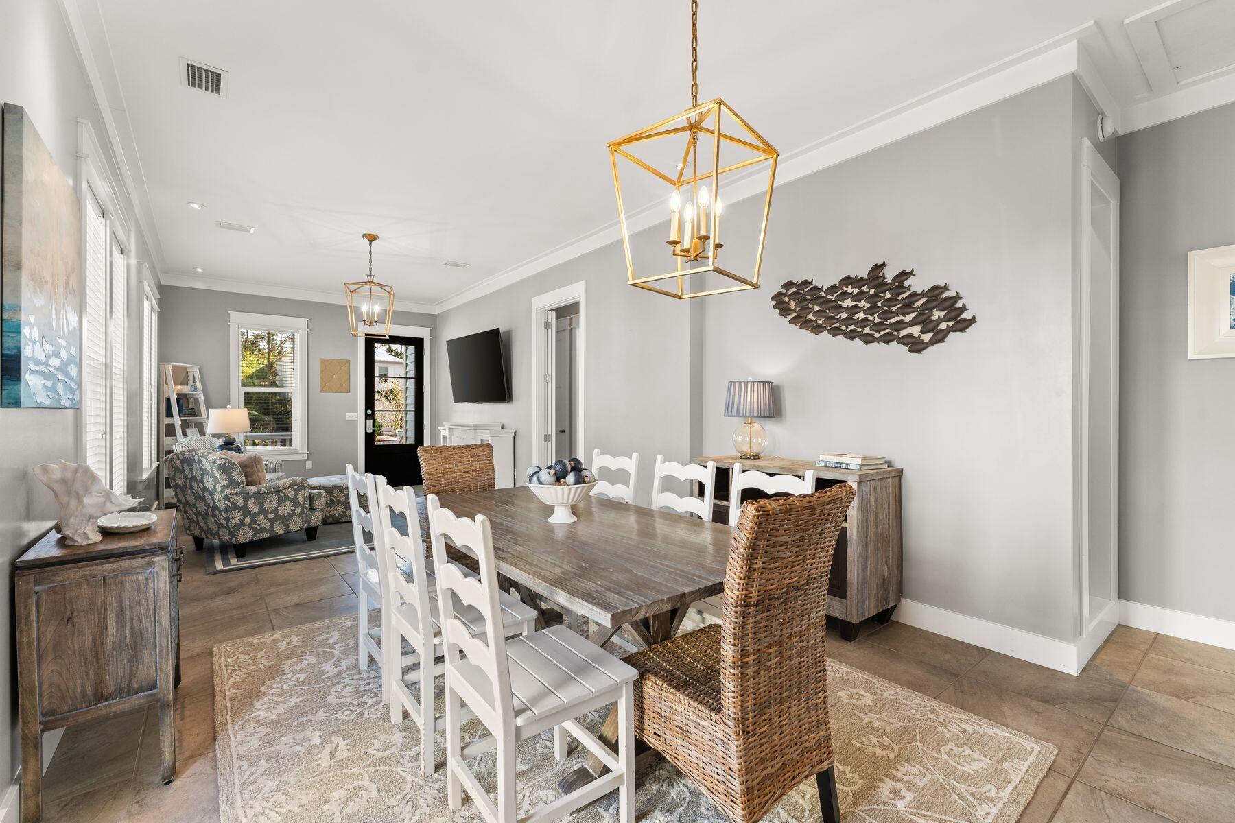 389 Seacrest Drive Seacrest, FL 32461 - Photo 3 of 33 a view of a dining room with furniture and chandelier