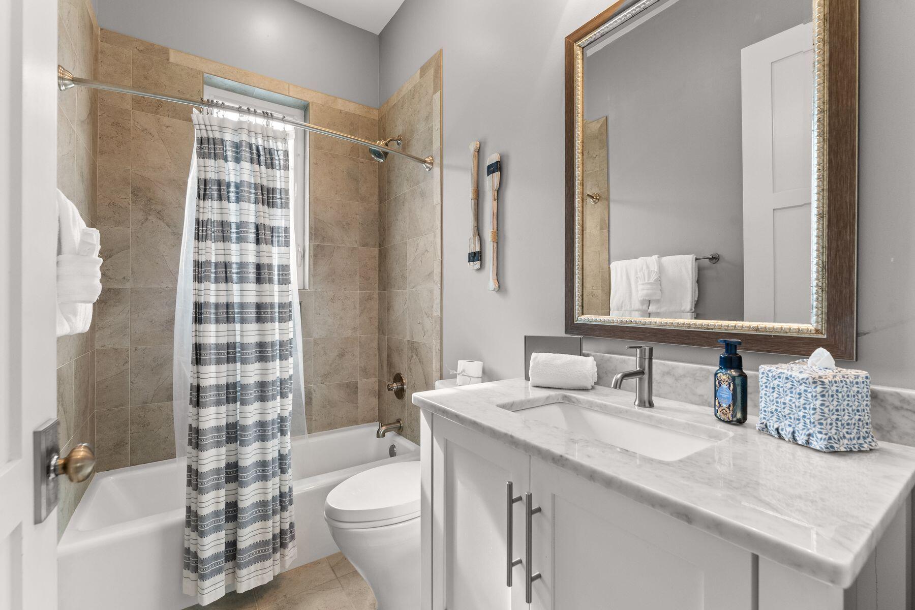 389 Seacrest Drive Seacrest, FL 32461 - Photo 5 of 33 a bathroom with a granite countertop sink toilet mirror and shower