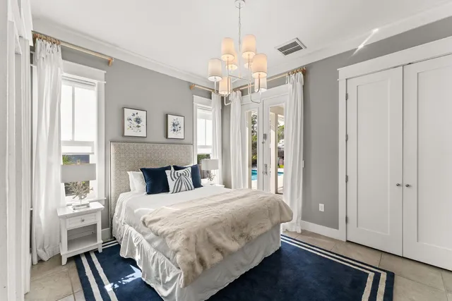 a bedroom with a large bed chandelier and a window