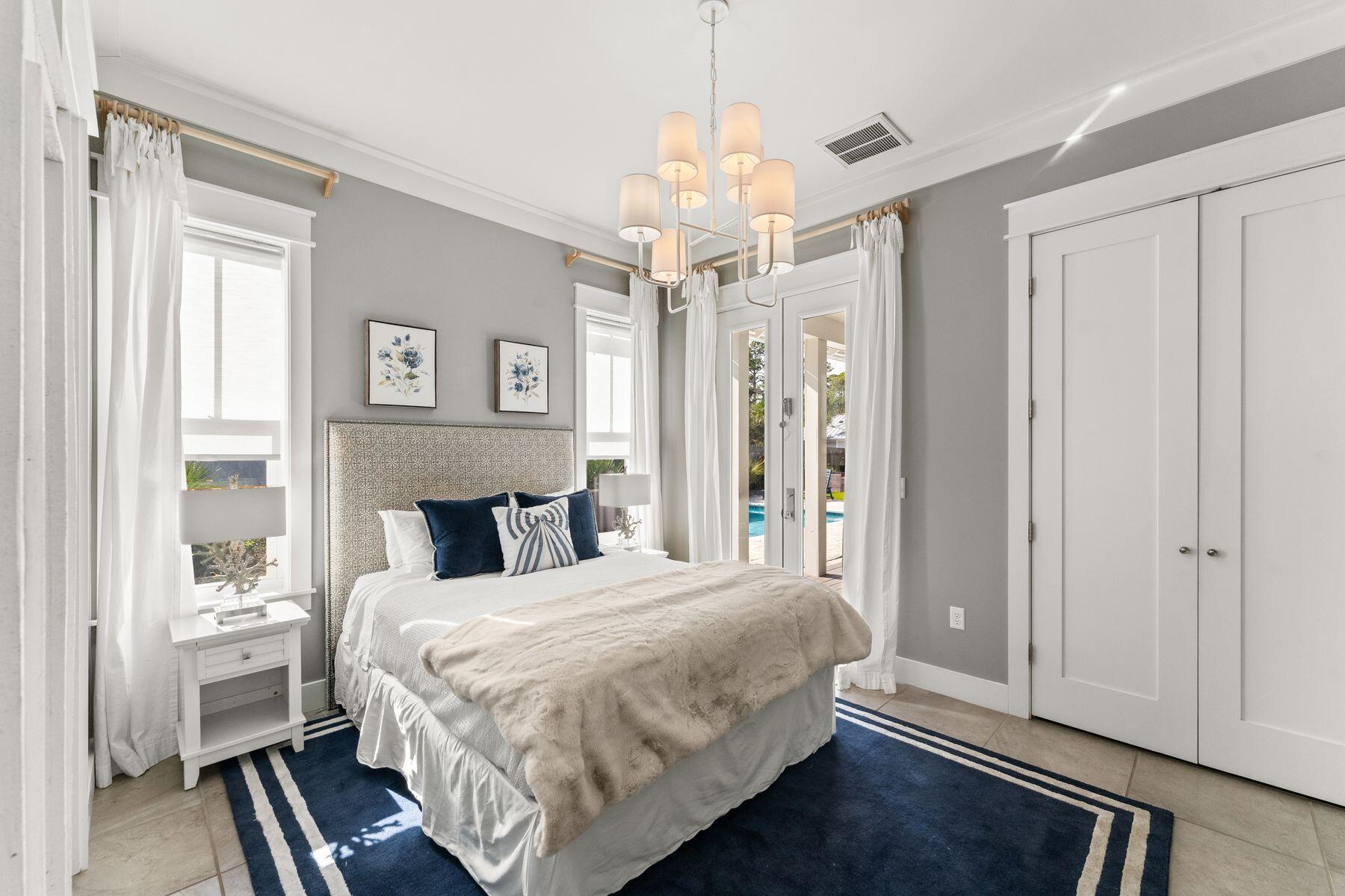 389 Seacrest Drive Seacrest, FL 32461 - Photo 7 of 33 a bedroom with a large bed chandelier and a window