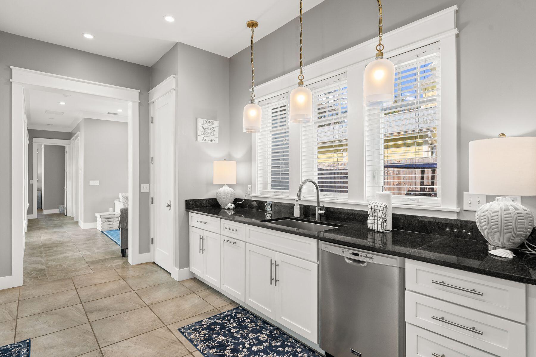 389 Seacrest Drive Seacrest, FL 32461 - Photo 9 of 33 a kitchen with granite countertop a sink and a white cabinets