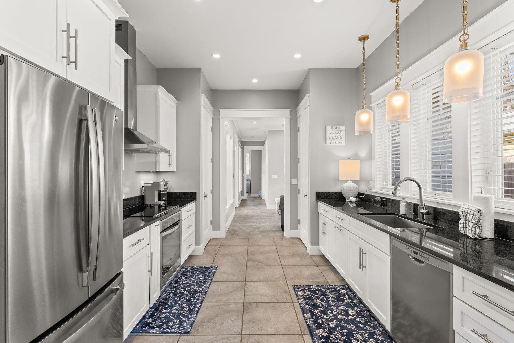 389 Seacrest Drive Seacrest, FL 32461 - Photo 10 of 33 a large kitchen with stainless steel appliances a large counter top a stove a chimney a refrigerator and a stove