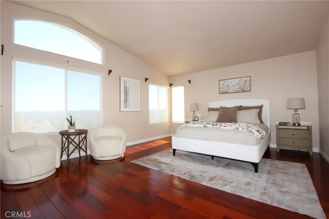 a spacious bedroom with a bed a table and chair