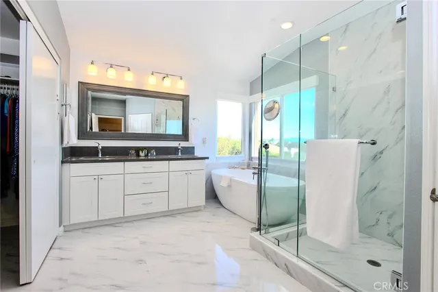 a bathroom with a granite countertop sink mirror and a bathtub