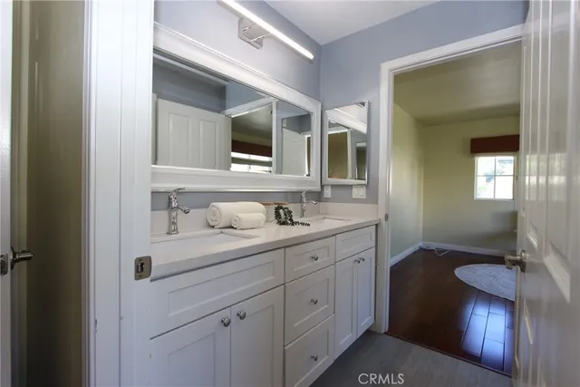 a en suite bathroom with a granite countertop sink and a mirror