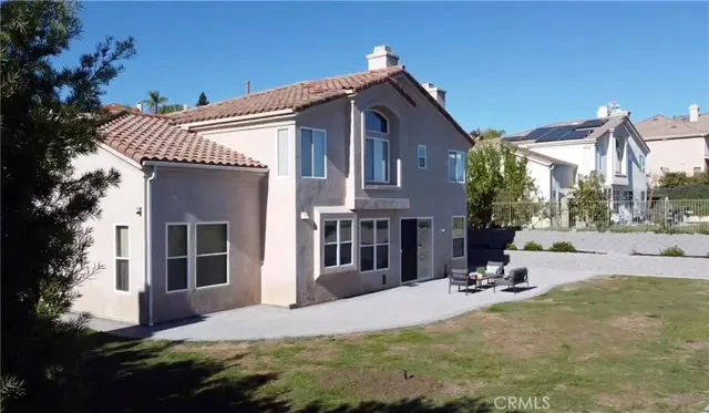 a view of a house with backyard and sitting area