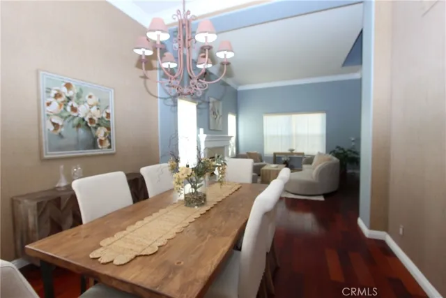 a living room with furniture a chandelier and a dining table