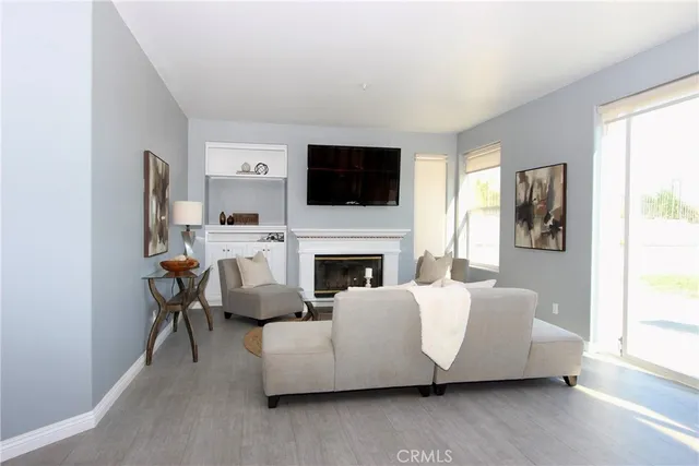 a living room with furniture a flat screen tv and a fireplace