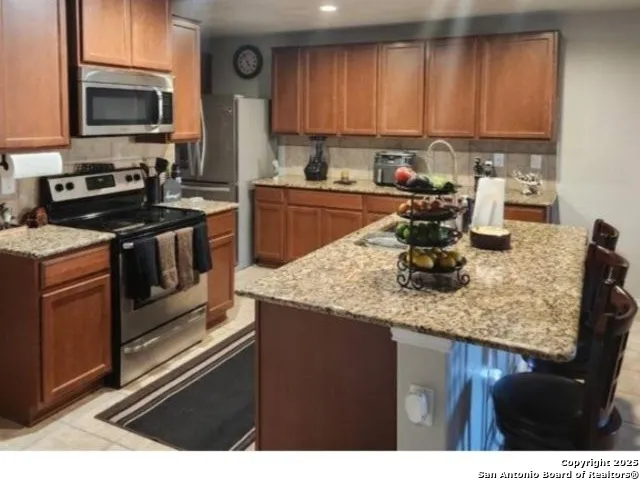 a kitchen with stainless steel appliances granite countertop a sink stove and microwave