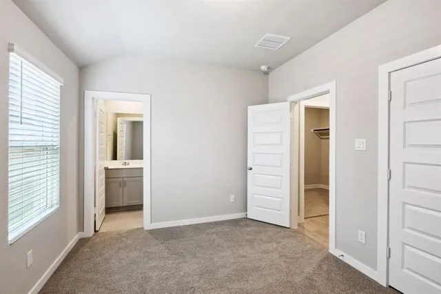an empty room with closet and windows