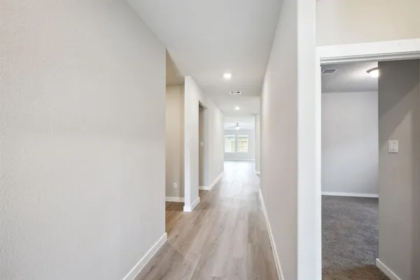 a view of a hallway with wooden floor