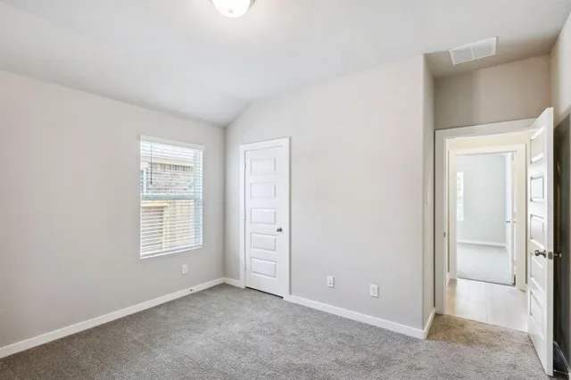 an empty room with windows and closet
