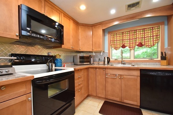 55 Christopher Road Waltham, MA 02451 - Photo 4 of 19 a kitchen with stainless steel appliances granite countertop a stove a sink and a microwave