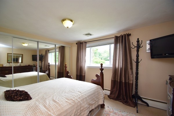 55 Christopher Road Waltham, MA 02451 - Photo 9 of 19 a bedroom with a bed and a flat tv screen on dresser