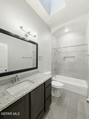 a bathroom with a granite countertop sink toilet and shower