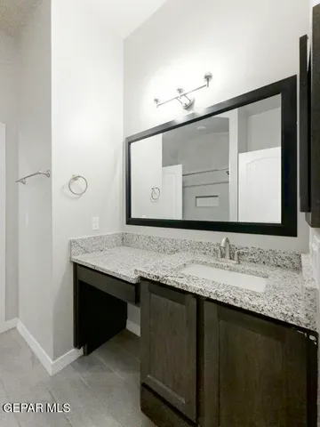 a bathroom with a granite countertop sink and a mirror