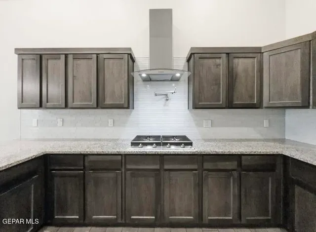 a large kitchen with stainless steel appliances a large counter top a sink and a refrigerator