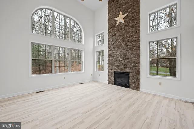 a view of an empty room with a window and fireplace