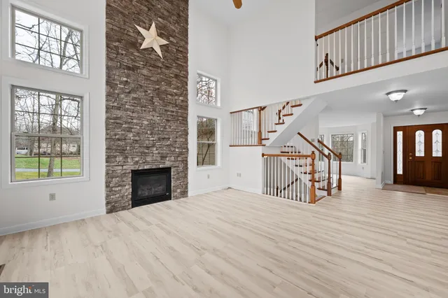 a view of empty room with wooden floor and a fireplace