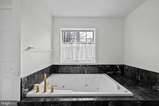 a bathroom with a bathtub and a window