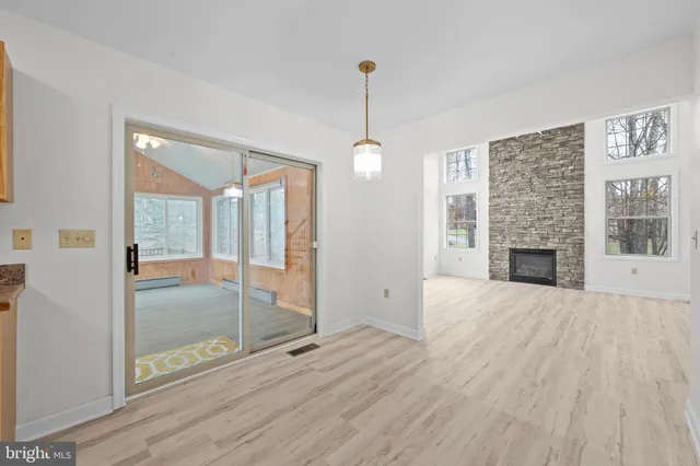 a view of an empty room with glass door and windows