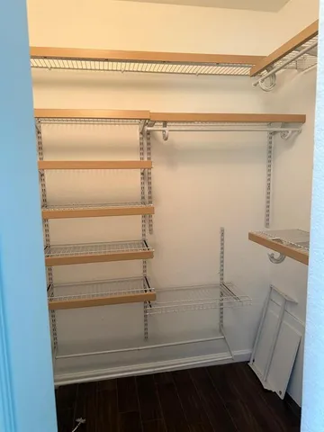 a view of walk in closet with empty racks