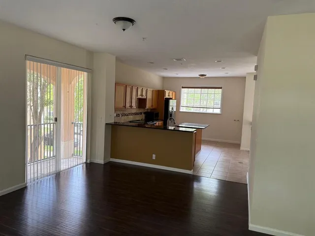 a view of a kitchen with wooden floor and a window