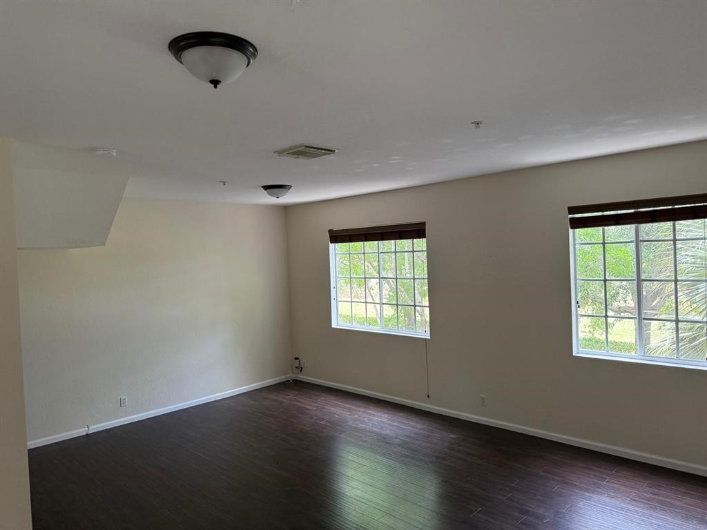 4573 Danson Way Delray Beach, FL 33445 - Photo 20 of 31 an empty room with wooden floor and windows
