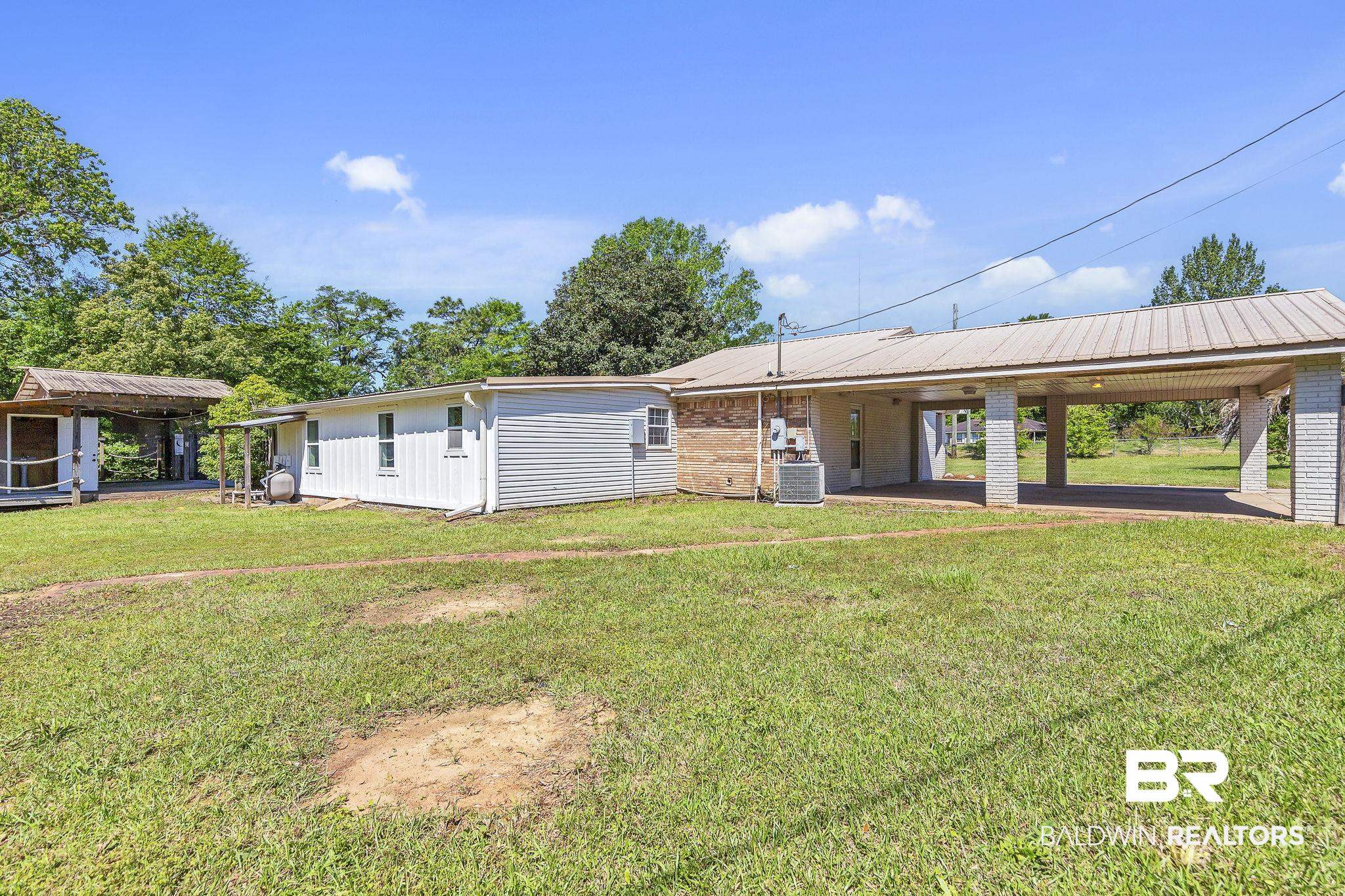 11964 Stroh Road Daphne, AL 36527 - Photo 45 of 58 Back of house with a carport, a yard, brick siding, and central AC